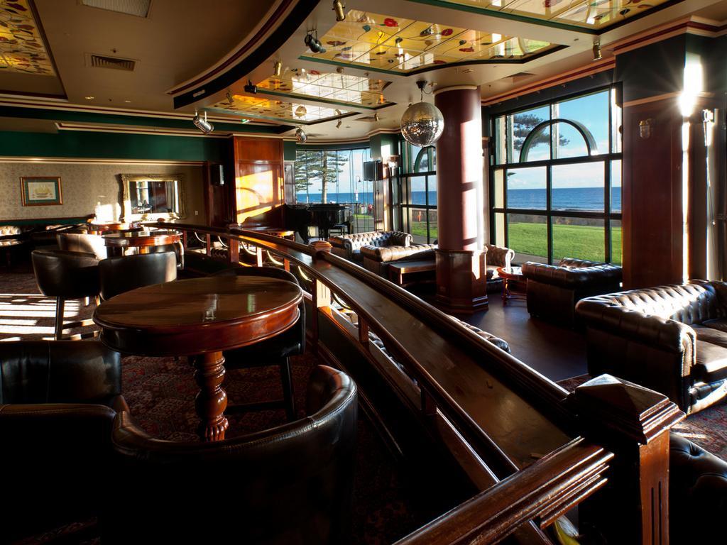 מלון גלנלג Stamford Grand Adelaide מראה חיצוני תמונה The photo depicts a stylish and inviting interior of a lounge or bar. It features comfortable leather seating, wooden tables, and large windows that provide a view of the outdoors. The ceiling is adorned with decorative elements, and there’s a disco 
