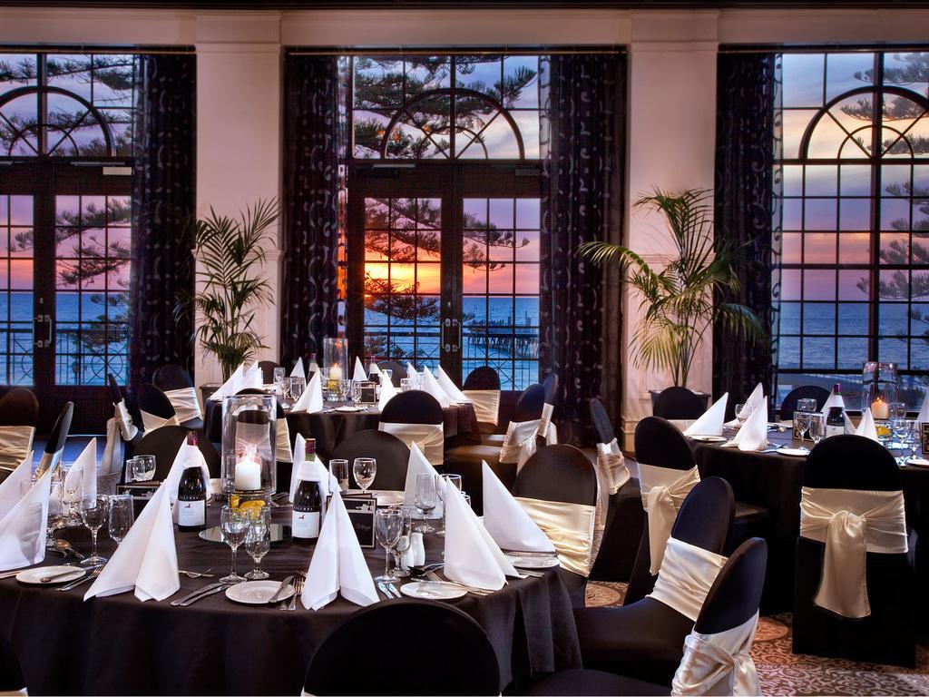 מלון גלנלג Stamford Grand Adelaide מראה חיצוני תמונה The photo shows an elegant dining setup inside a venue with large windows. The tables are adorned with black tablecloths and white napkins arranged in a stylish manner. Each table has glassware and other dining utensils placed neatly. In the backgrou