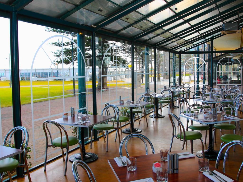 מלון גלנלג Stamford Grand Adelaide מראה חיצוני תמונה The photo shows the interior of a restaurant with a modern design. The space features several tables with green chairs, arranged in a way that allows for ample seating. Large glass windows provide a view of the outside, creating a bright and open atm