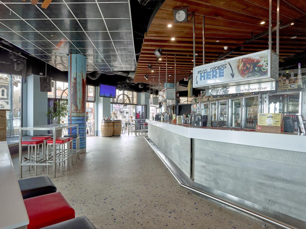 מלון גלנלג Stamford Grand Adelaide מראה חיצוני תמונה The photo shows the interior of a modern bar or restaurant. The design features a long, white counter that serves as the bar area, with a glass display showing beverages. Behind the bar, there are shelves for drink storage. The space has a mix of sea