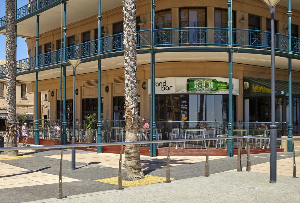 מלון גלנלג Stamford Grand Adelaide מראה חיצוני תמונה The photo shows a corner of a building that houses a bar with the name "End Bar" prominently displayed. It's a multi-level structure with balconies featuring decorative railings. In front of the bar, there are tables and chairs, indicating a dining o